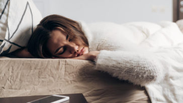 woman sleeping with a phone next to her bed