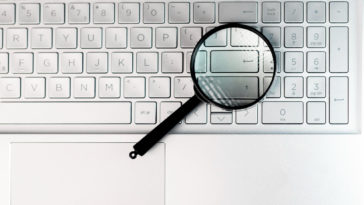 magnifying glass on top of a laptop enter key