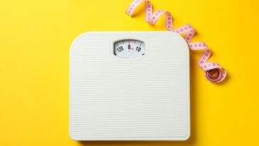 a scale and a measuring tape with a yellow background