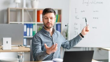 man giving remote English language lessons via a laptop