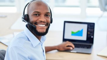 sales representative wearing a headset working on a laptop