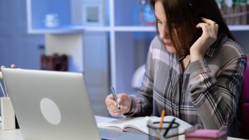 woman sitting at a desk wearing headphones