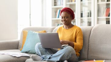 woman sitting on a couch with a laptop in her lap