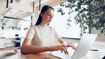 woman sitting at a desk working on a laptop