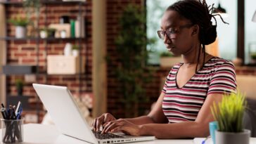 woman working on a laptop from a home office