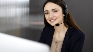 smiling girl with a headset working on a computer